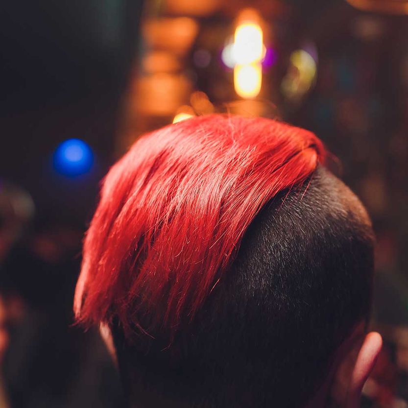 Scheitelpunkt des jungen Mannes mit dem roten Haar, das über weißem Hintergrund aufwirft. Nahansicht