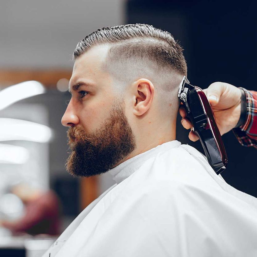 Friseur mit einem Kunden. Mann mit Bart. Typ in einem Friseursalon